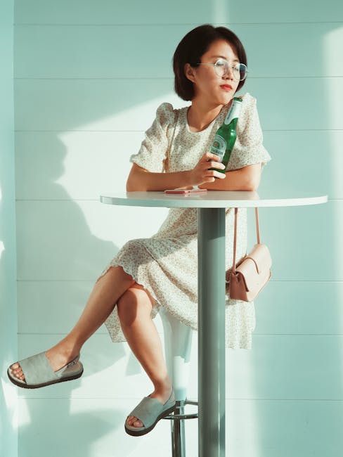 Smiling woman in a comfortable seated pose, eyes closed, meditating in a bright, airy room.